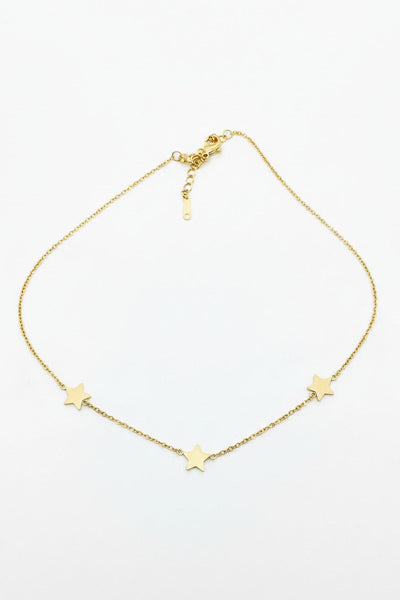 Gold necklace with star-shaped pendants on a light gray background
