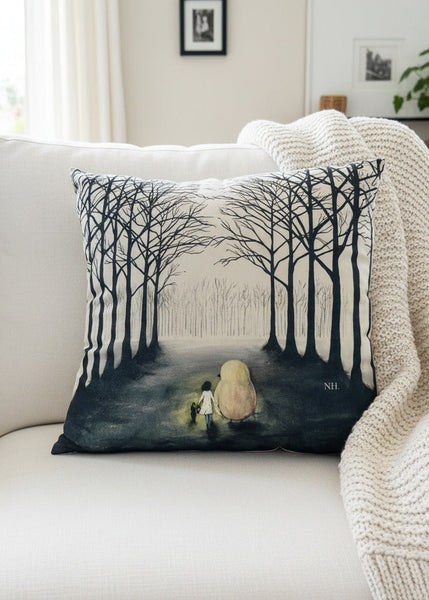 Decorative pillow with tree design on a surface with books and artwork in the background